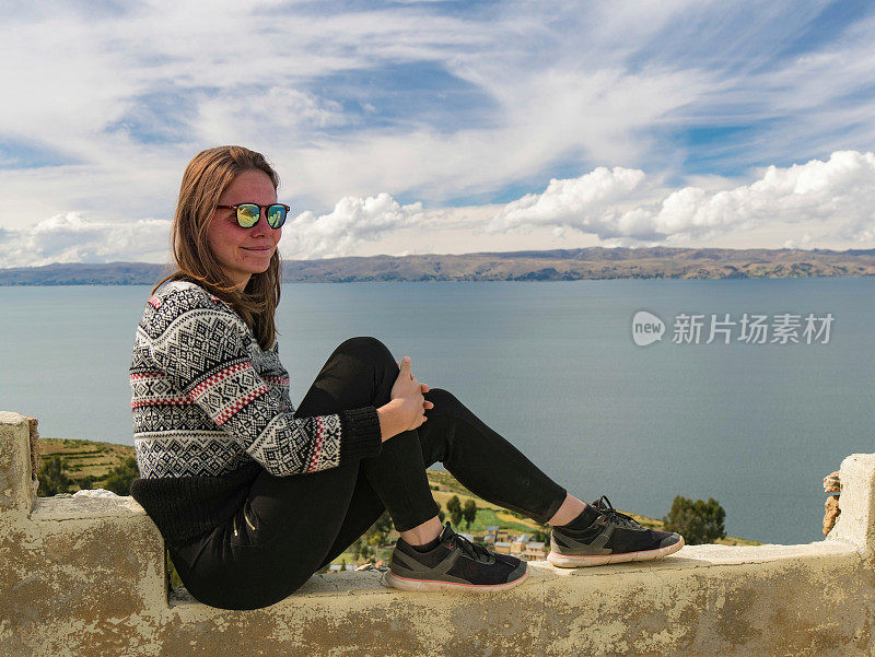 年轻女子的肖像坐在美丽的风景上的太阳岛，isla del sol，秘鲁